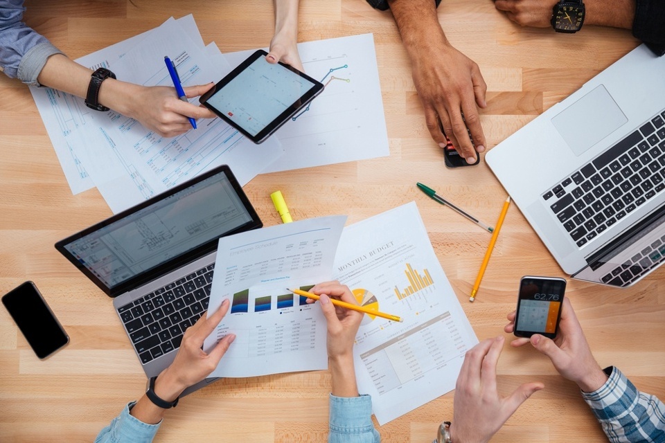 Group of people working with laptops, tablet and smartphones together and making financial report-1.jpeg